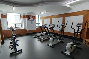 Un gimnasio con cintas de correr, elípticas y bicicletas estáticas.