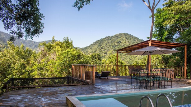 A pool area with a pergola, outdoor seating, and a view of a mountainous landscape. - HOTEL MINCA LA CASONA (Santa Marta)