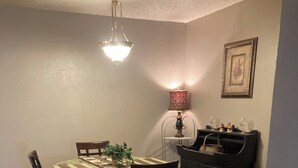 A dining area with a table, chairs, a lamp, a cabinet, and a rug. - Movie Matinee Hideaway  (Oklahoma City)