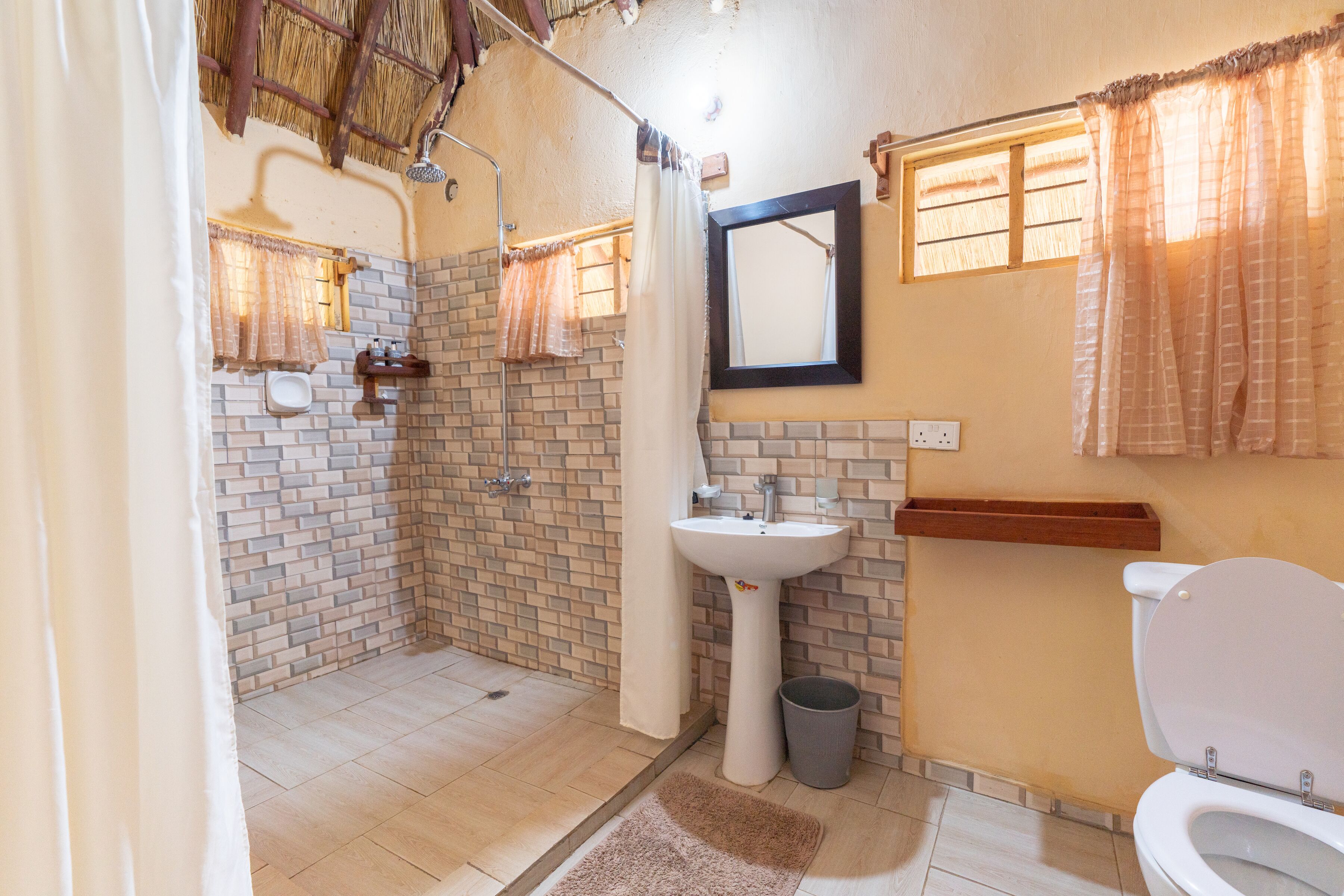 A bathroom with a shower, sink, and toilet.