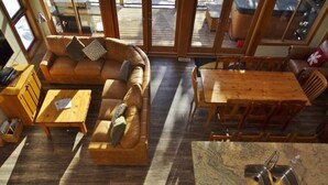 Un ambiente accogliente con un divano in legno, un tavolo da pranzo e un angolo cottura con lavello.