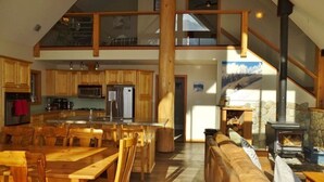 Un'ampia cucina con mobili in legno e un'area pranzo con un grande tavolo e sedie in legno.