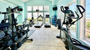 Un gimnasio con cintas de correr, mancuernas y equipamiento de ejercicio.