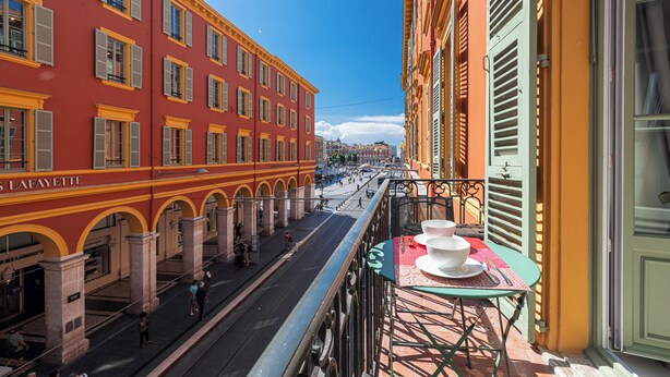 A street view with a red building labeled "Lafayette" and a balcony with a table and chairs. - Luxury Apartment BY Massena Square (Nice)