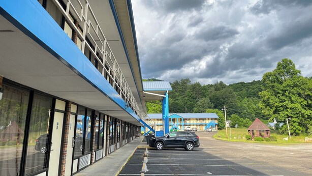 Ein Gebäude mit blau-weißer Fassade, großen Fenstern und einem Parkplatz.
