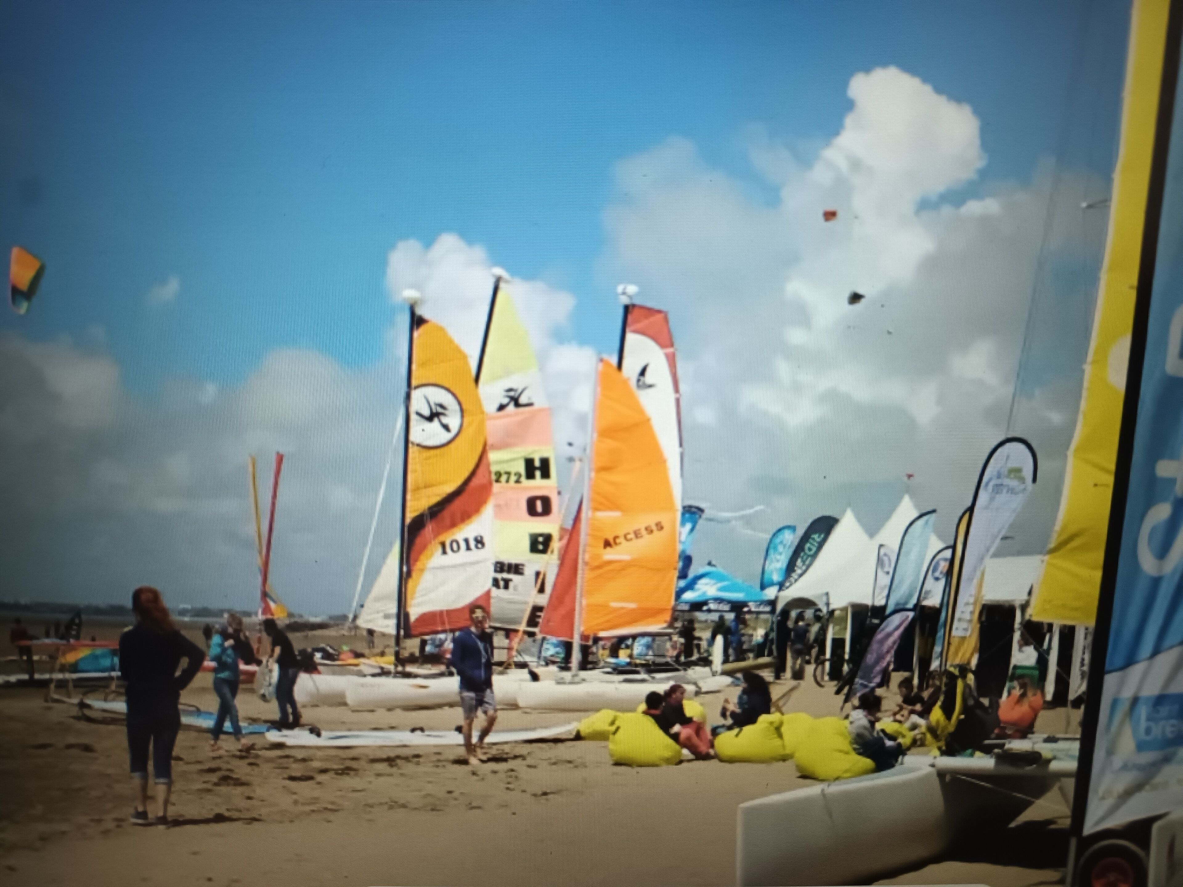 A beach with sailboats and people.