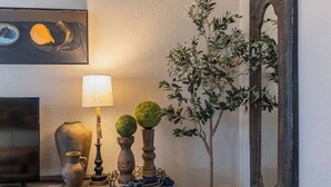 Eine Wandleuchte, ein kleiner Tisch mit Dekoration und ein Spiegel.