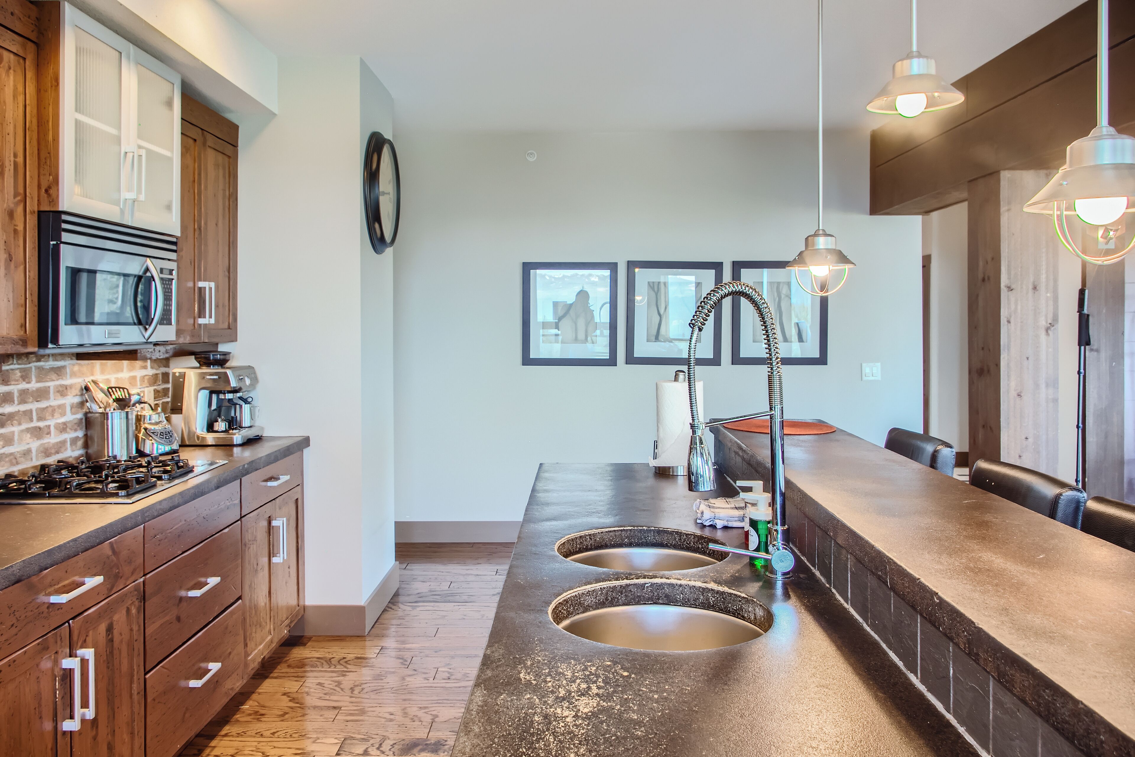 A modern kitchen with a central island, stainless steel appliances, and wooden cabinetry.