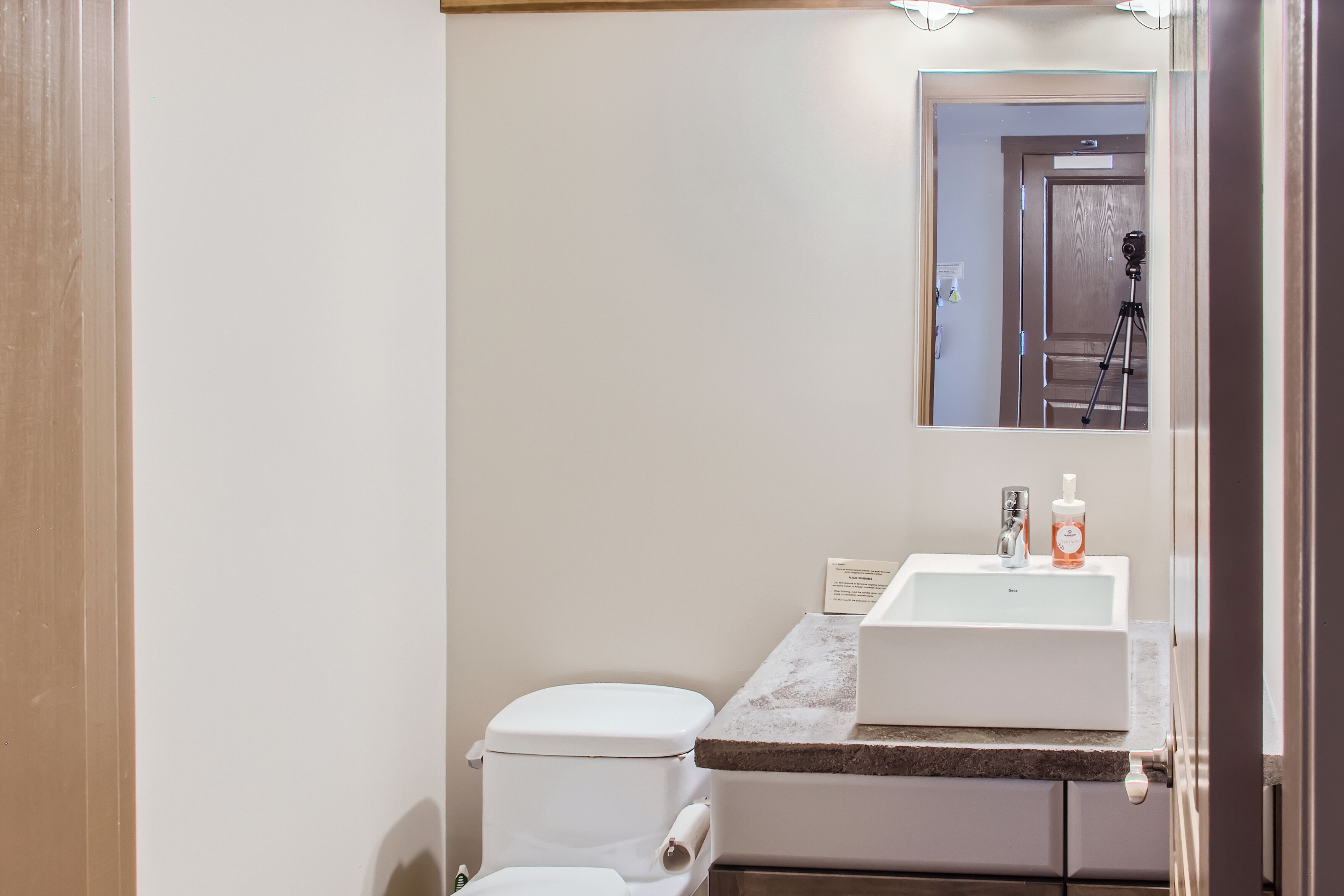 Ein Badezimmer mit Toilette, Waschbecken und Spiegel.