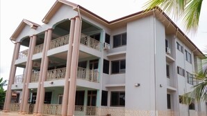 A multi-story building with balconies and a tiled ground floor. - Joyful Haven apartments (Nkoranza)