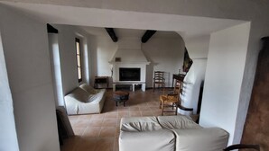 Un salón amplio con chimenea, un sofá y un comedor.