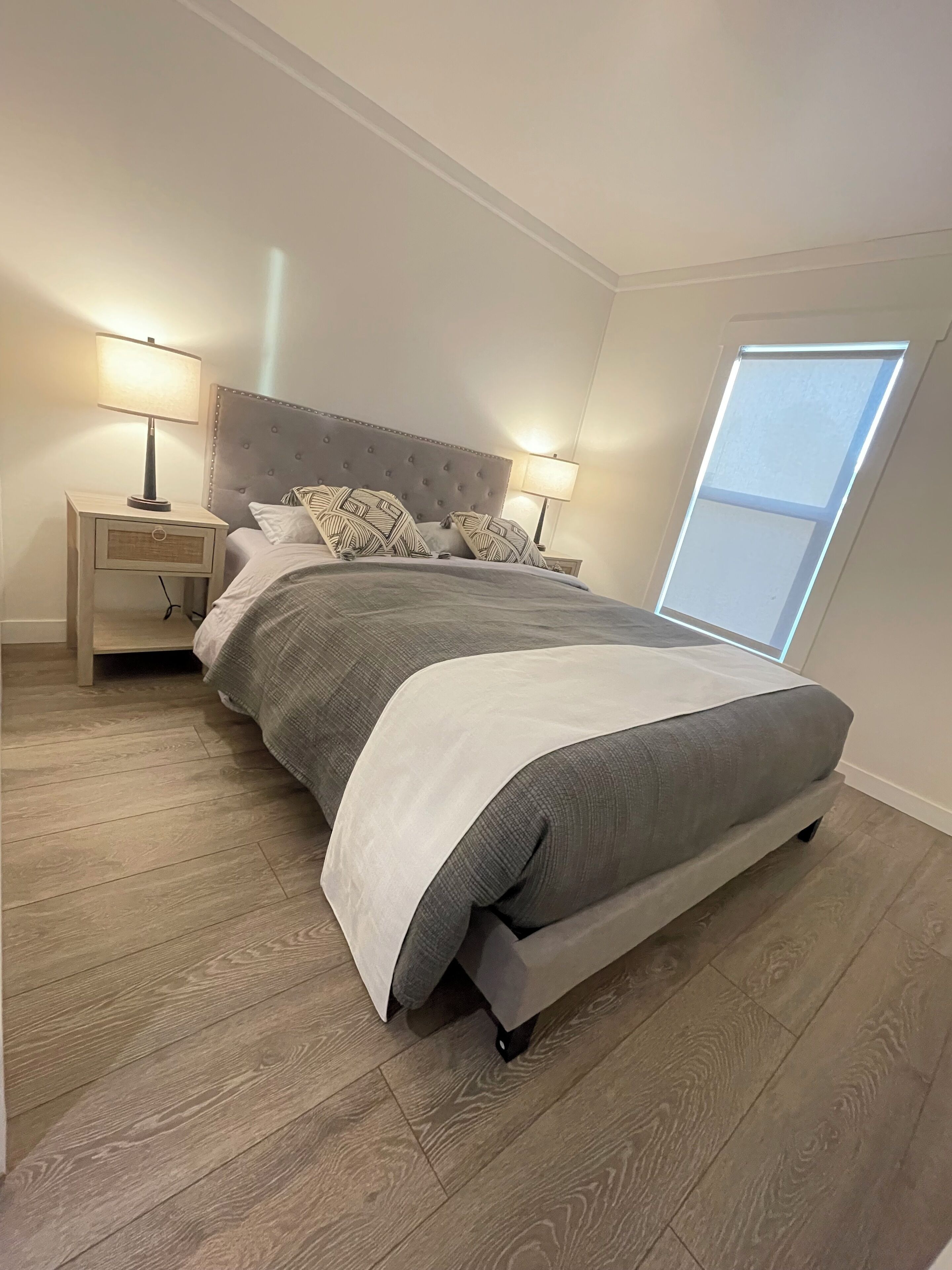 A bedroom with a bed, two bedside tables, and a skylight.
