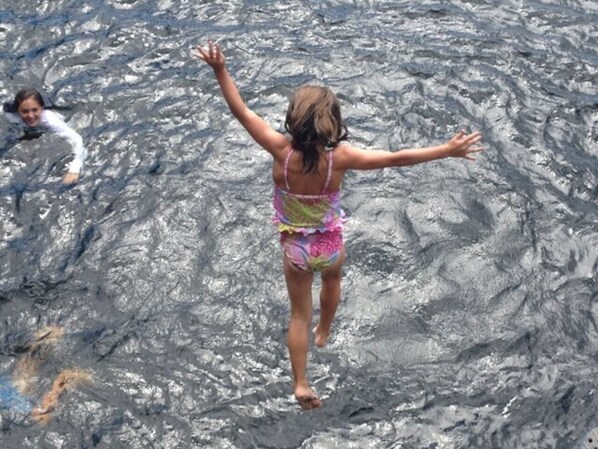A person in a colorful swimsuit jumping into water.