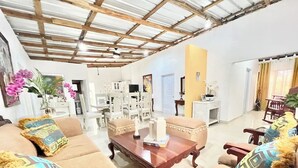 A spacious living room with a high ceiling, a dining area, and a kitchen in the background. - Private cottage in Boca Chica for 15 guests (Boca Chica)