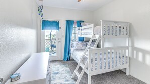Una habitación con literas, un escritorio y un ventilador de techo.