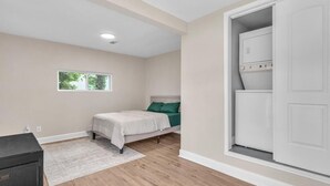 Ein Schlafzimmer mit Bett, Fenster, Kleiderschrank und Kommode.