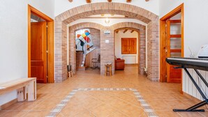 A spacious hallway with a tiled floor, wooden doors, and a brick fireplace. - Cozy home in Guardiola de Fontrubí with sauna (Guardiola de Fontrubí)