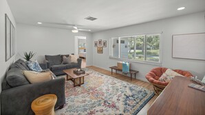 A modern living room with a grey sofa, a wooden coffee table, and a patterned rug. - Reserve your stay today! Canal-front rental with a boat dock available. (Crystal River)
