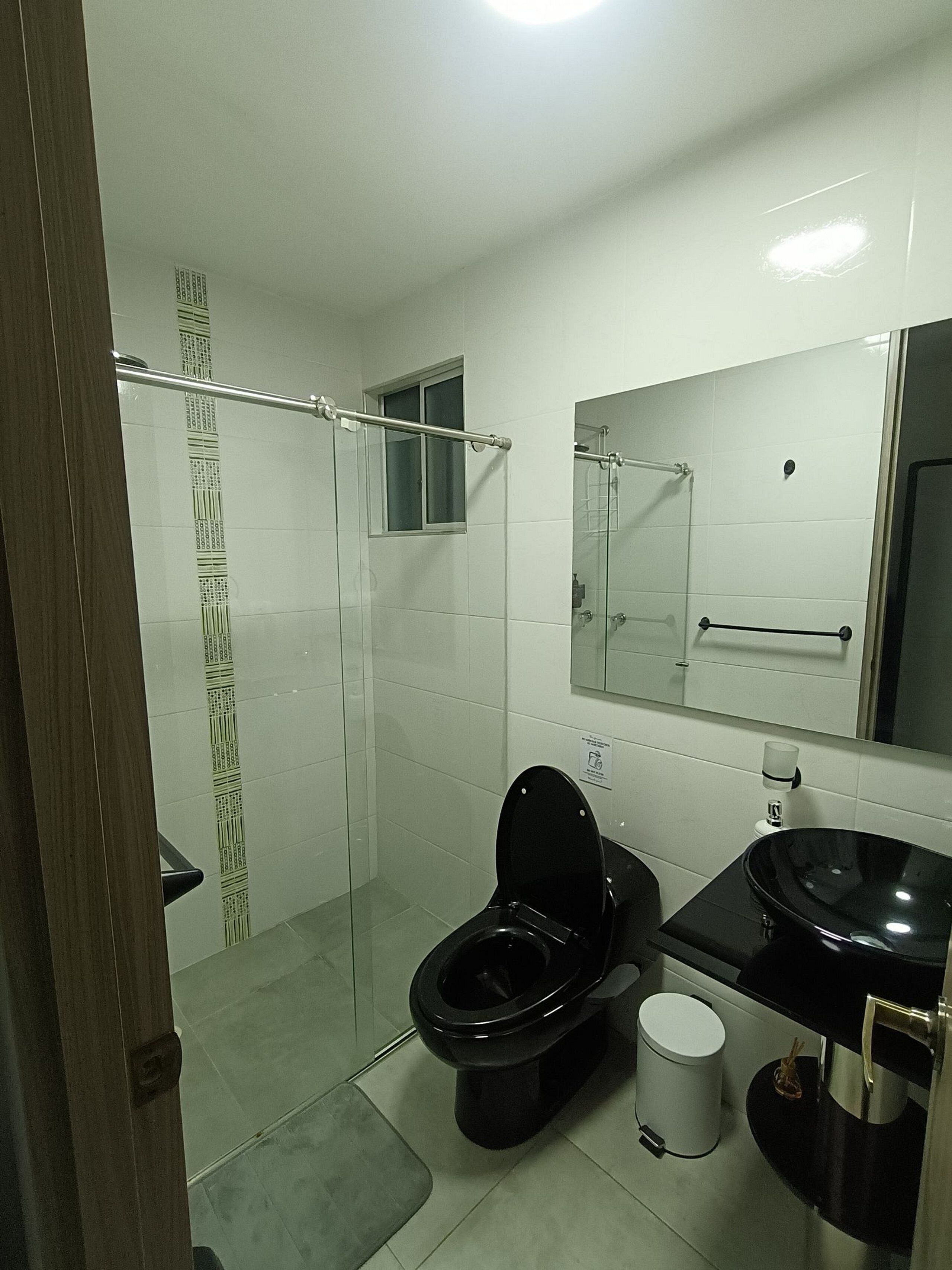 A bathroom with a toilet, sink, and shower area.