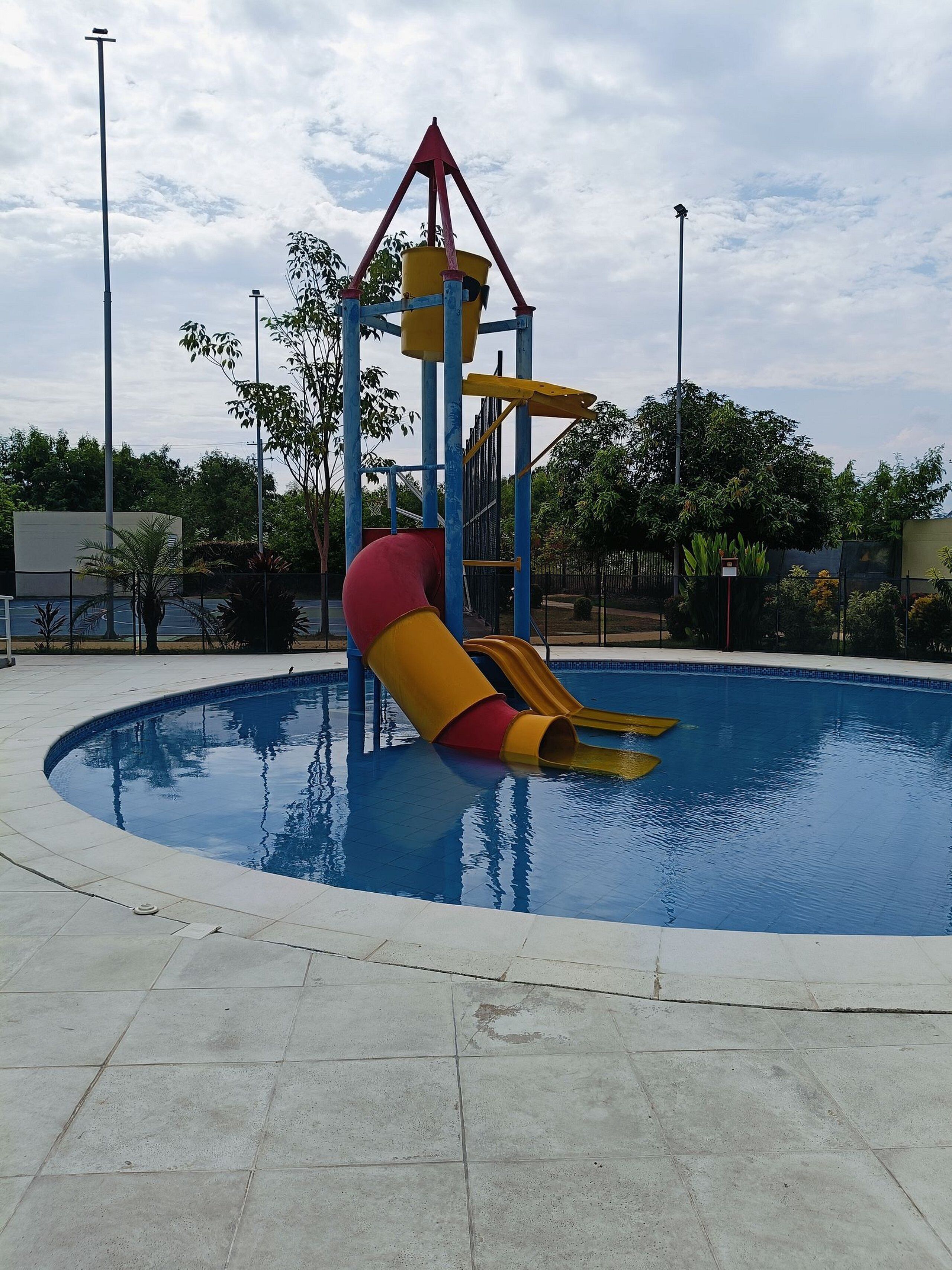 Una piscina con tobogán y estructura de escalada.