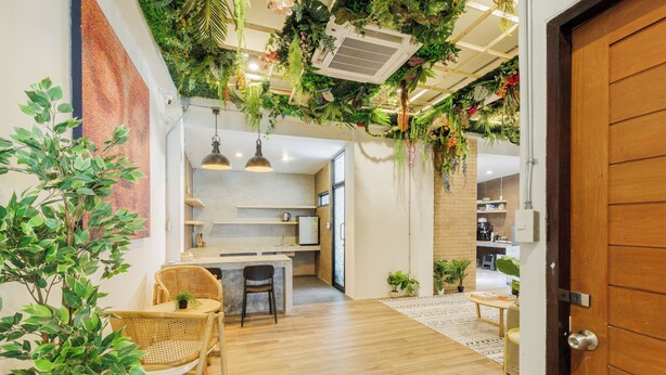 Une cuisine moderne avec un plancher en bois, un coin repas avec une table et des chaises, et un espace de vie avec un canapé et une table basse.