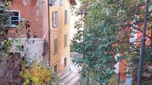 Un escalier étroit en pierre mène à un bâtiment dont le toit est recouvert de tuiles.