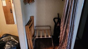 A compact room with a bunk bed, a small table, and a chair. There is a curtain partially drawn, and a vacuum cleaner is visible. - Schuss Village Studio Unit 117 True Ski-in/Ski-out. (Bellaire)