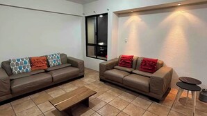 A living room with two sofas, a coffee table, and a window.