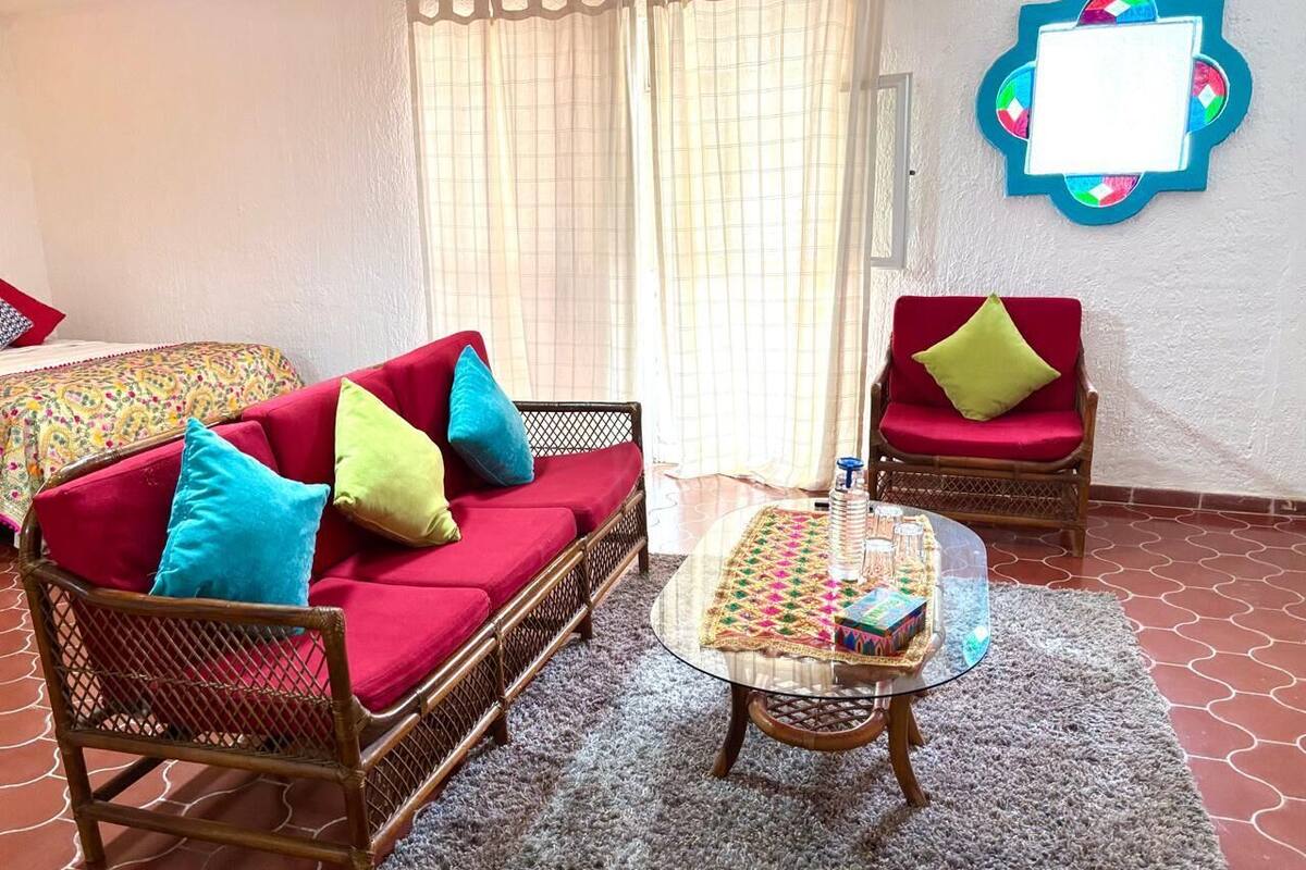 A living room with a sofa, two armchairs, a coffee table, and a patterned rug.
