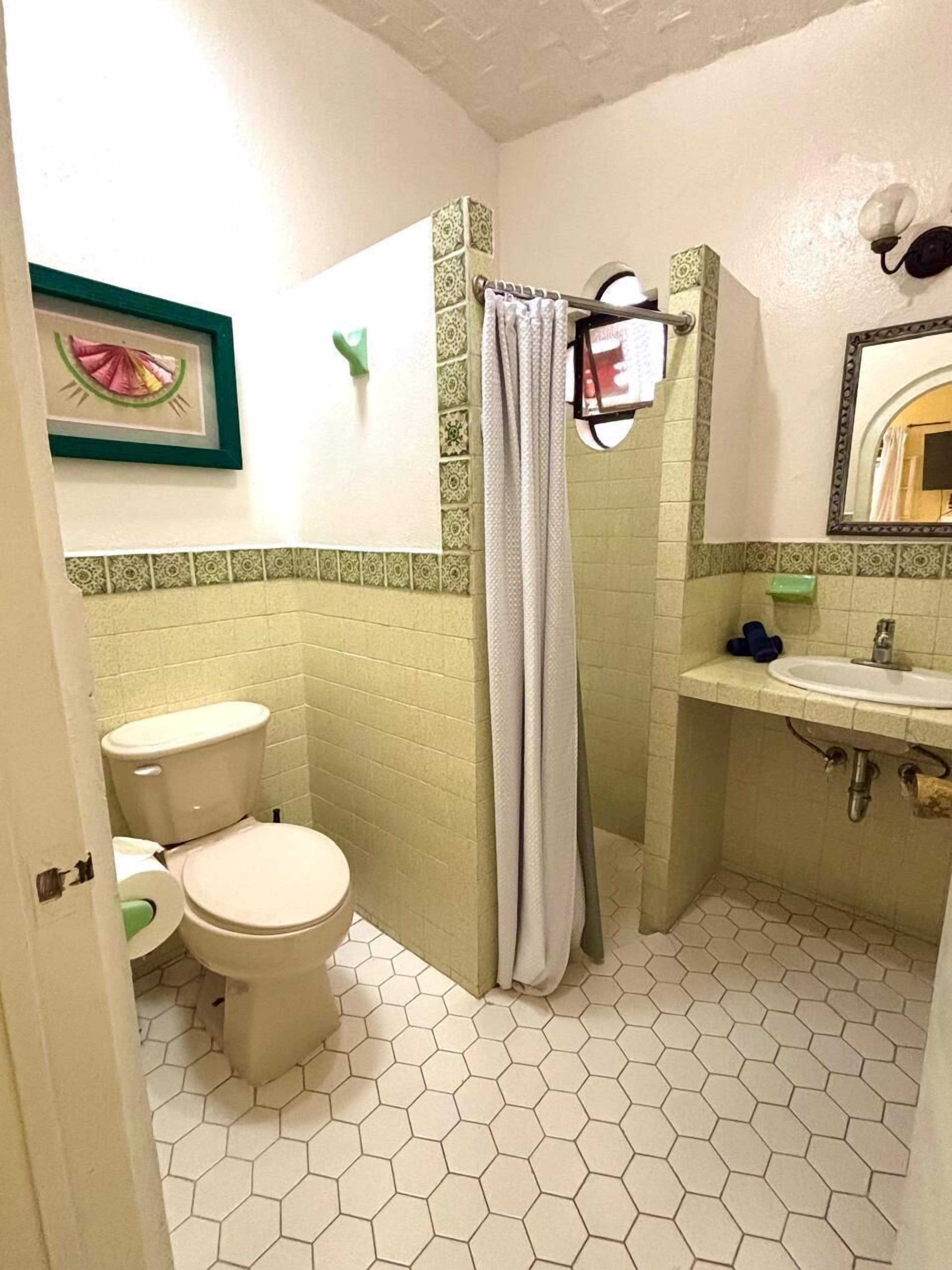 Un baño pequeño con inodoro, ducha y lavamanos.