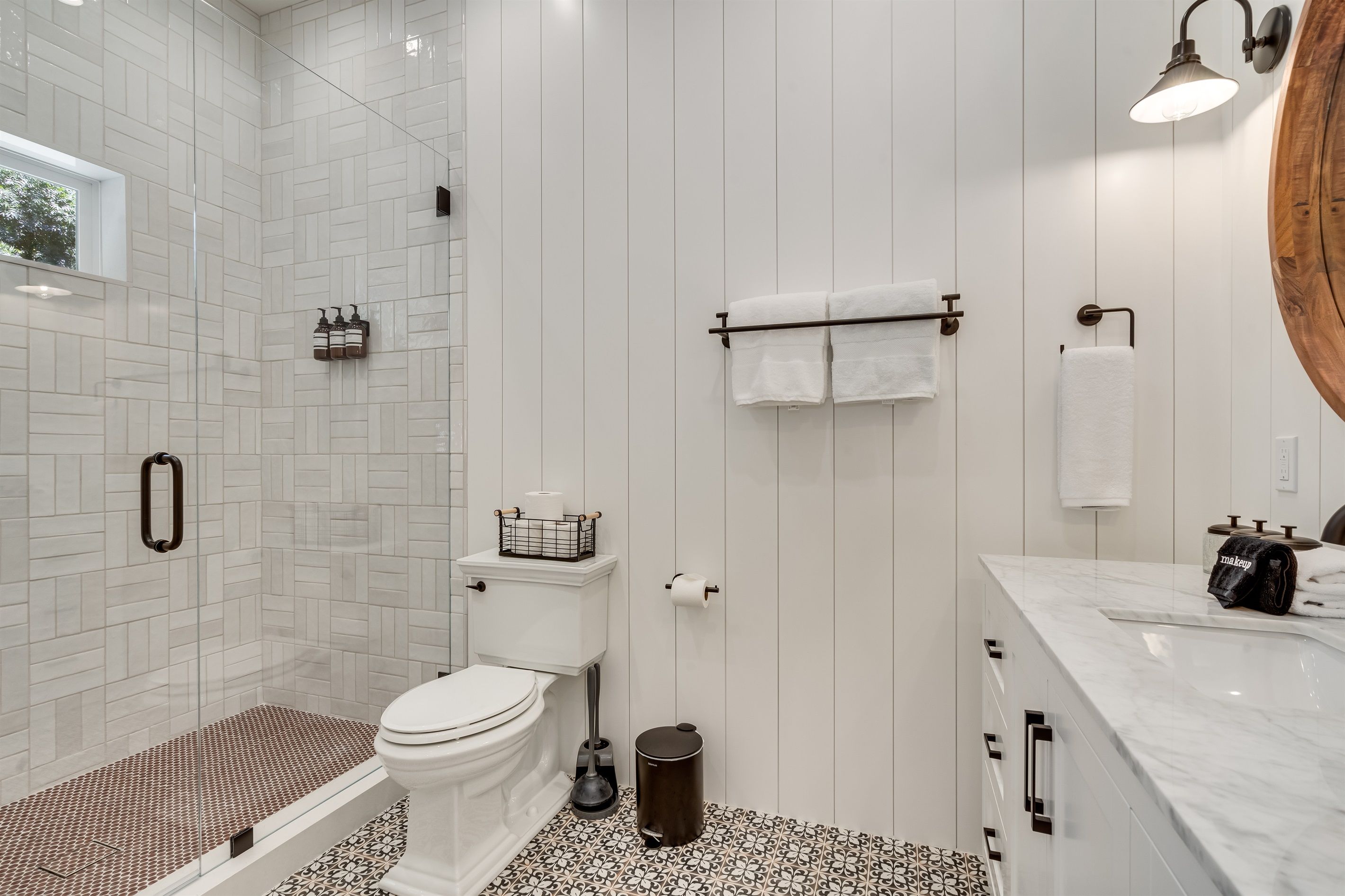 A modern bathroom with a shower, toilet, and sink.