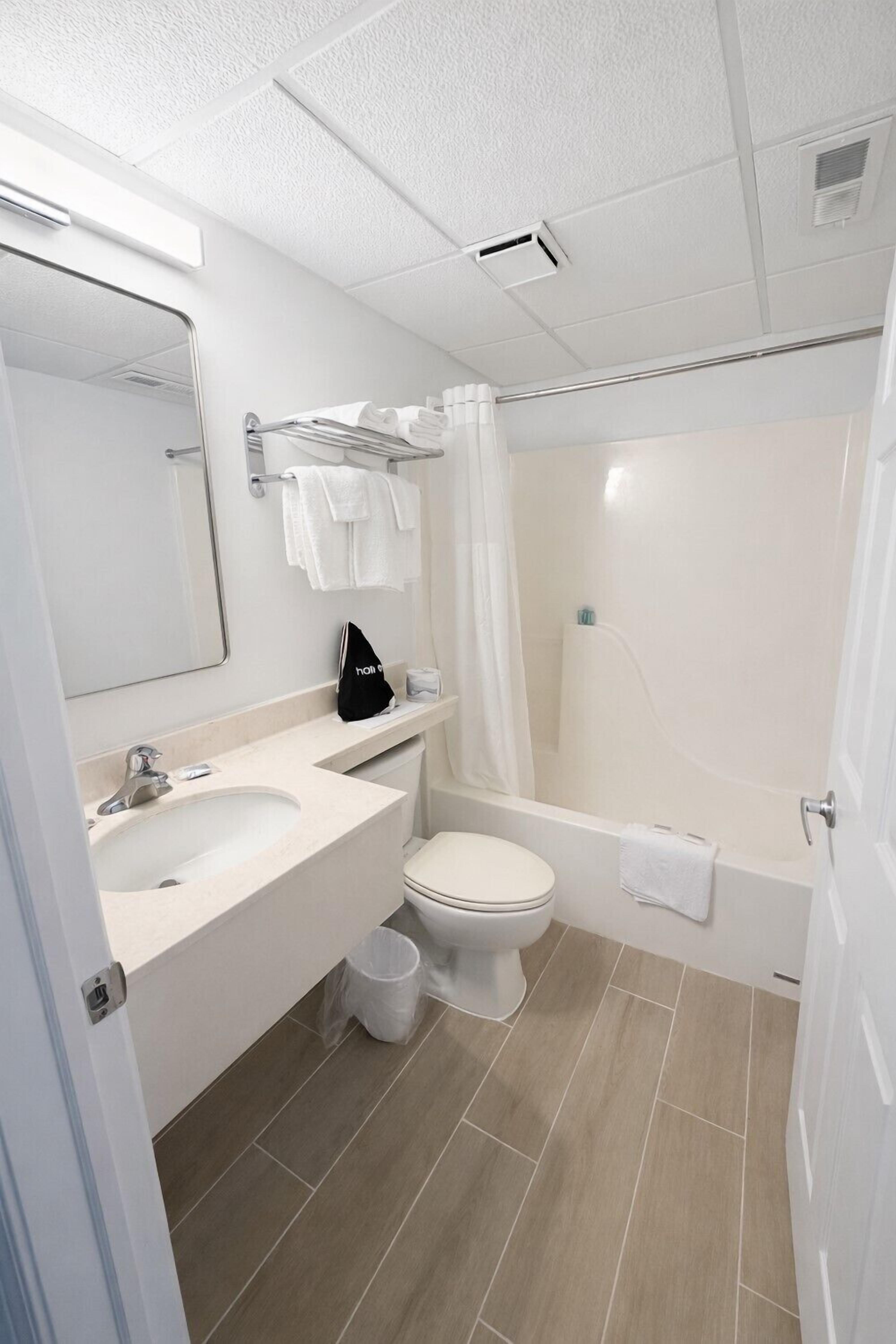 A modern bathroom with a sink, toilet, and bathtub.