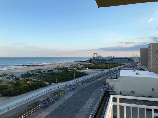 Vista costera con playa, muelle y edificios industriales.