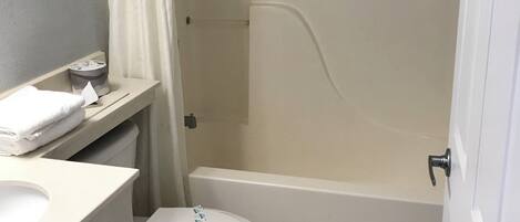 A bathroom with a toilet, sink, and bathtub.