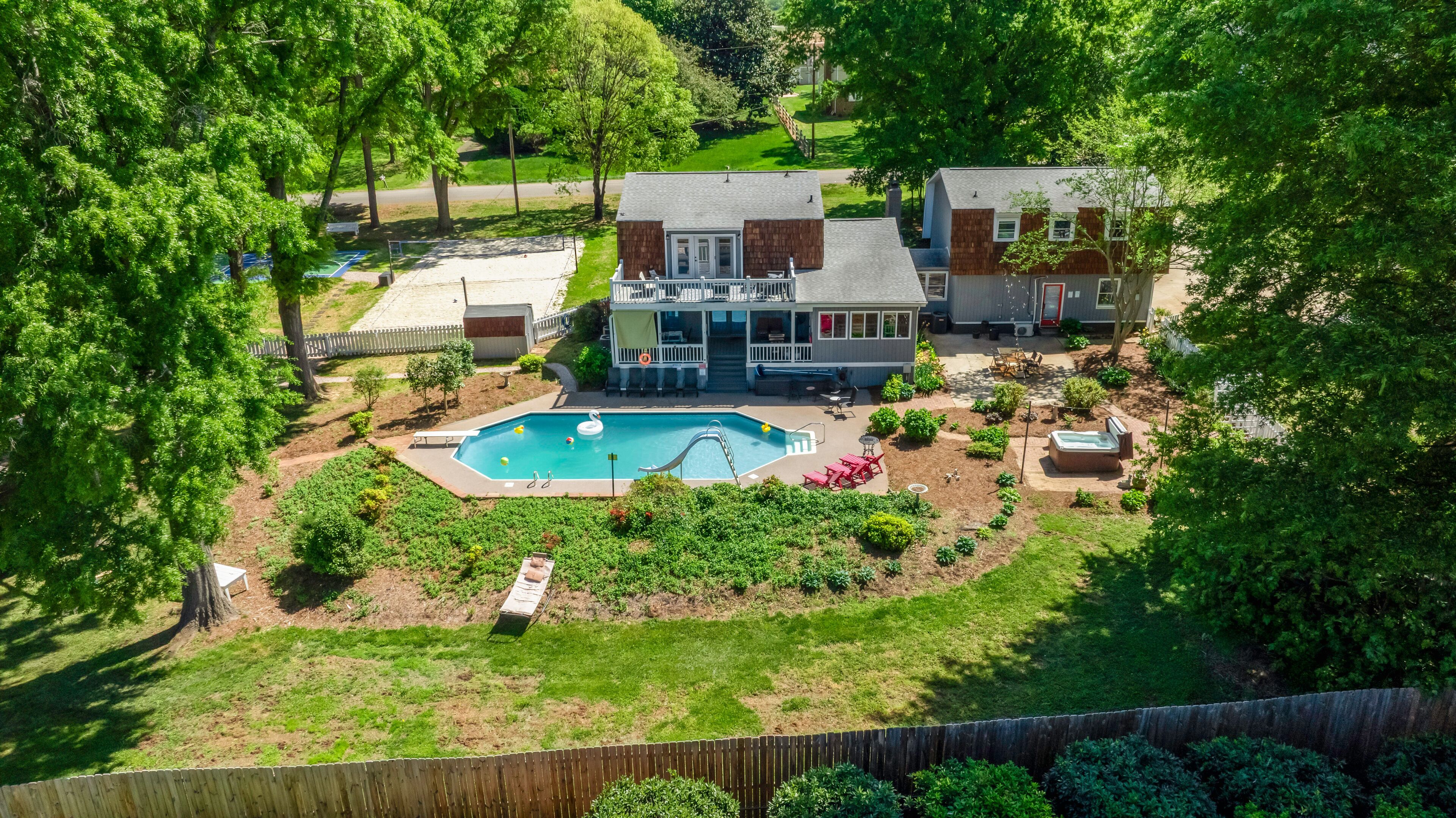 A residential property with a swimming pool, a covered patio, and a fenced yard.