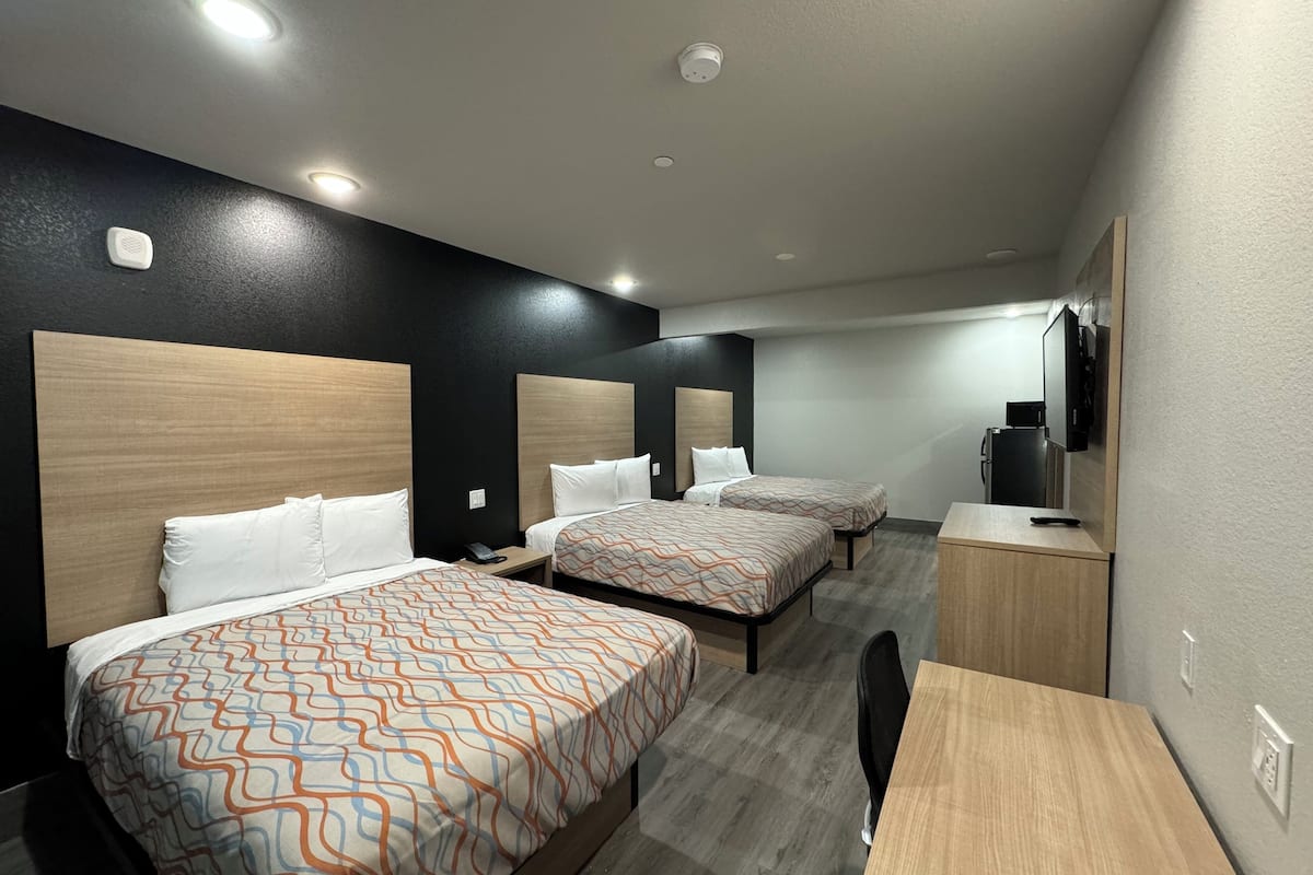 Deluxe Triple Room | Desk, laptop workspace, blackout drapes, iron/ironing board