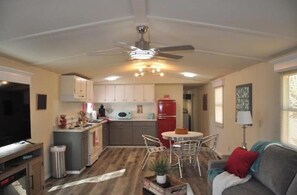 A compact living space with a kitchenette, dining area, and a television.
