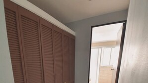 A room with a sliding door leading to a balcony, a tiled floor, and a ceiling with a light fixture. - Torre Metropoli (Cancun)
