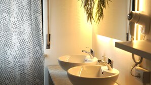 A bathroom with two sinks, a mirror, and a hanging plant. - Vitti's home verona 2 - Cittadella  (Verona)