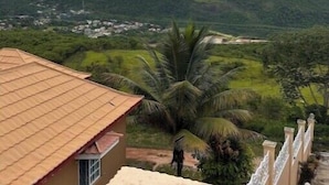 Vista de un barrio residencial con una casa de techo de tejas y un balcón.