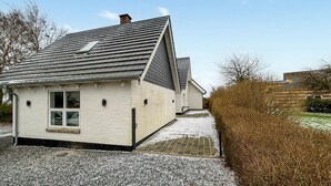 A small, single-story house with a sloped roof and a chimney.