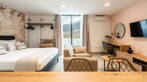 Une chambre d’hôtel moderne équipée d’un lit, d’un bureau, d’une chaise et offrant une vue sur l’extérieur.