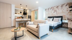 Une chambre à coucher moderne avec un lit, un canapé et une petite table.