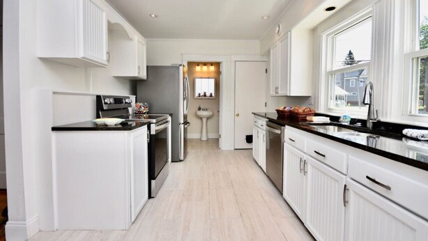 A modern kitchen with white cabinetry, a black countertop, and stainless steel appliances. - "Good Vibes" 4 Wonderful Seasons @ Portland Home! (Portland)