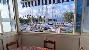 Una mesa y sillas de madera en una habitación con vista a un puerto deportivo.