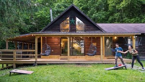 A wooden cabin with a porch, large windows, and a star decoration.