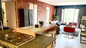 A modern kitchen with a central island, a gas stove, and a refrigerator. - Depto in beautiful Soho Morelos, new, 2 bedrooms (Guadalajara)