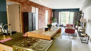 A modern kitchen with a gas stove, wooden cabinets, and a brick accent wall. - Depto in beautiful Soho Morelos, new, 2 bedrooms (Guadalajara)