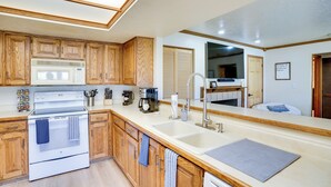A modern kitchen with wooden cabinets, a built-in microwave, and a large sink. - Hiking & Explore: Brian Head Condo w/ Indoor Pool! (Brian Head)