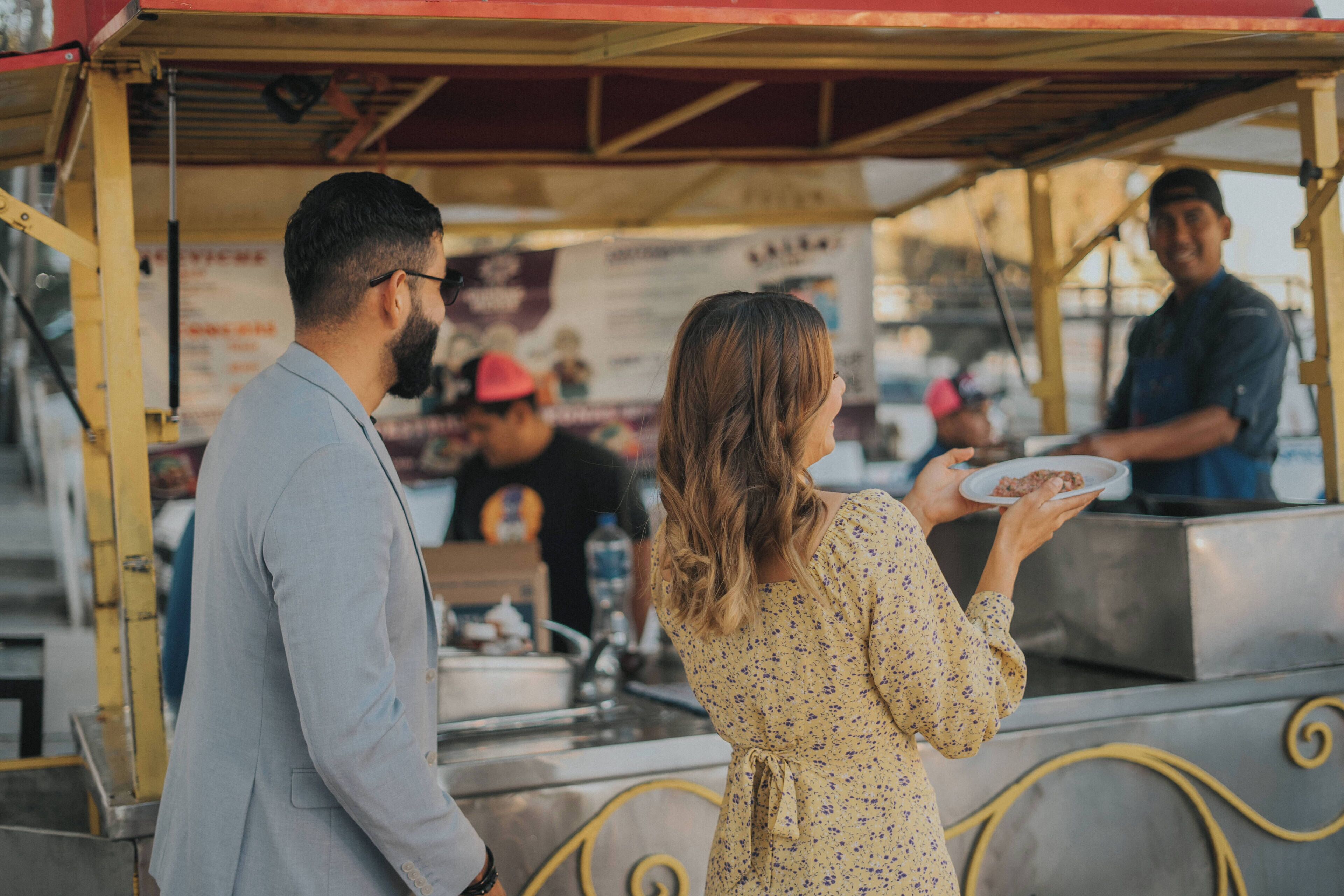 A street food vendor stall with a metal counter and a yellow awning.